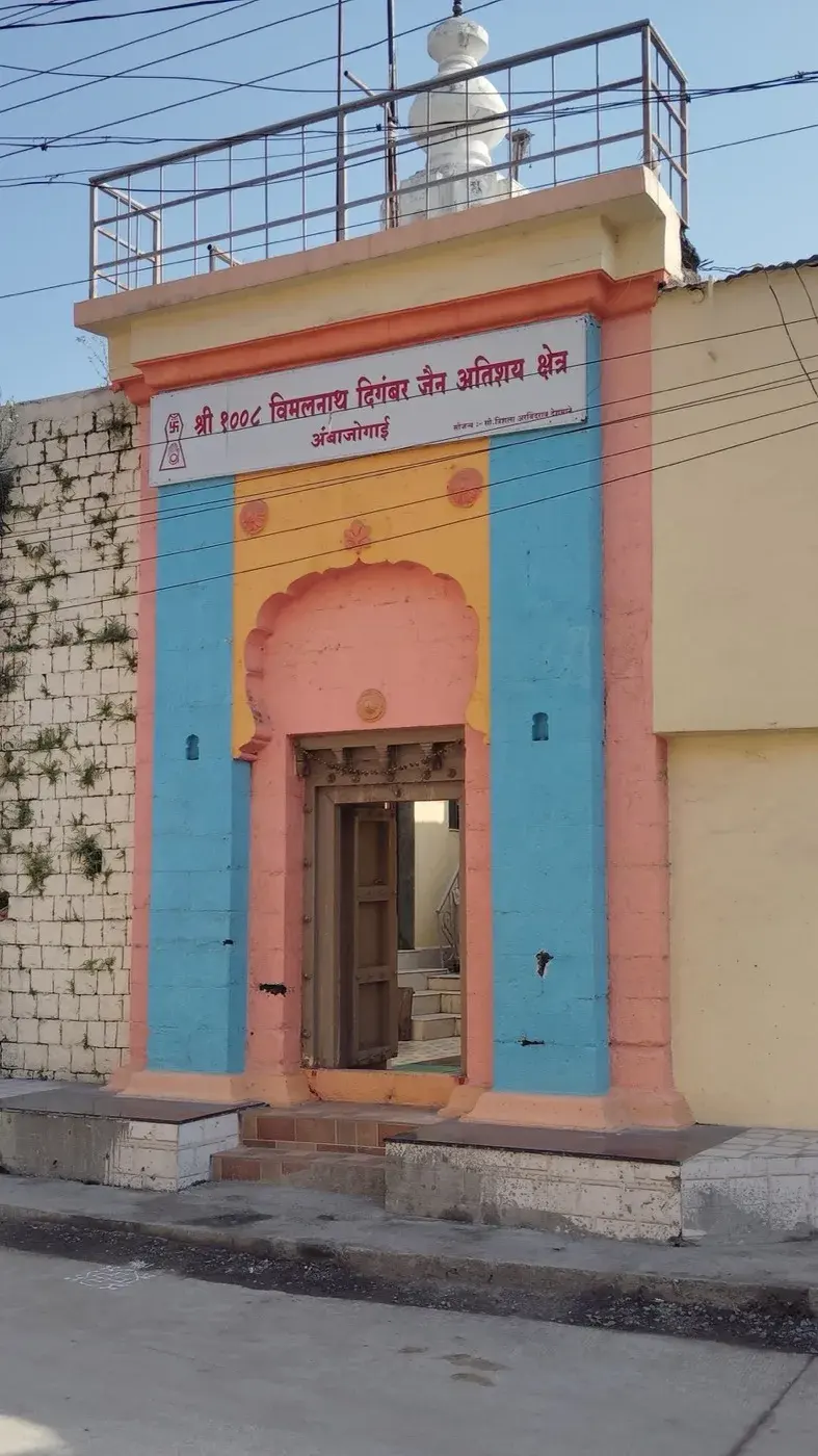 The kshetra's entrance seen from further down the street, its rooftop terrace and a small white finial visible above the boundary wall.